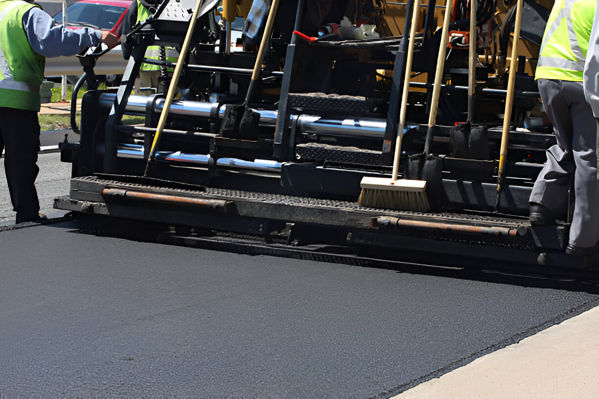 Professional asphalt paving process in McDermott, Ohio with machinery and workers in safety vests executing roadwork.